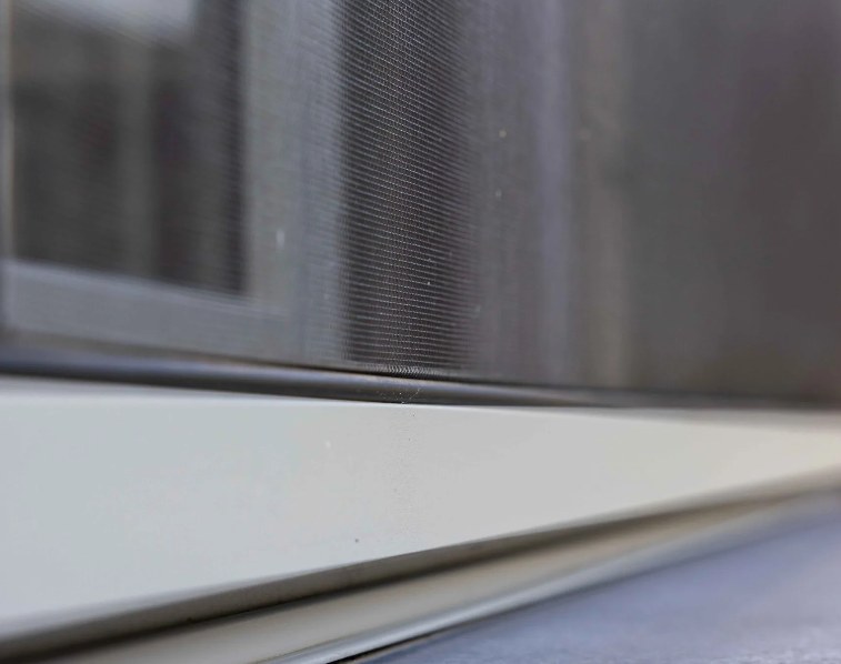 Détail d'une moustiquaire sur une fenêtre coulissante
