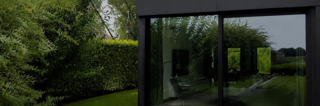 Baie vitrée coulissante en aluminium noir donnant sur un jardin