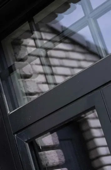 Fenêtre en aluminium noir sur façade en briques