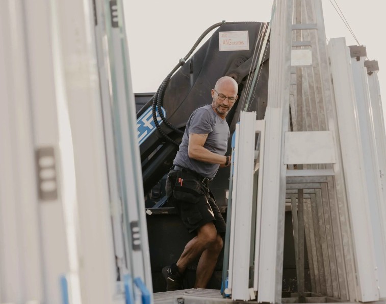 Poseur près d'un camion chargé de profilés