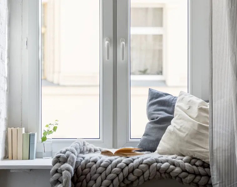 Coin fenêtre cosy avec banquette et coussins